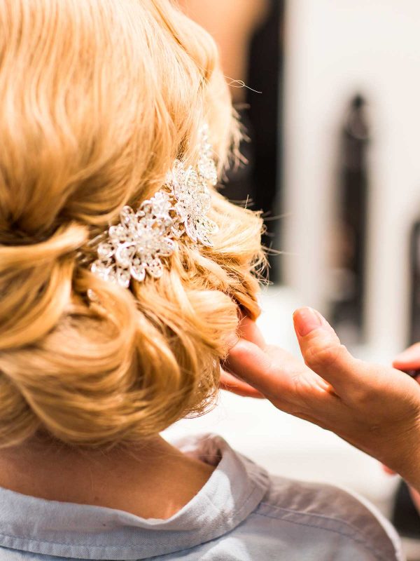 hair-stylist-makes-the-bride-before-a-wedding-PQRL9MD
